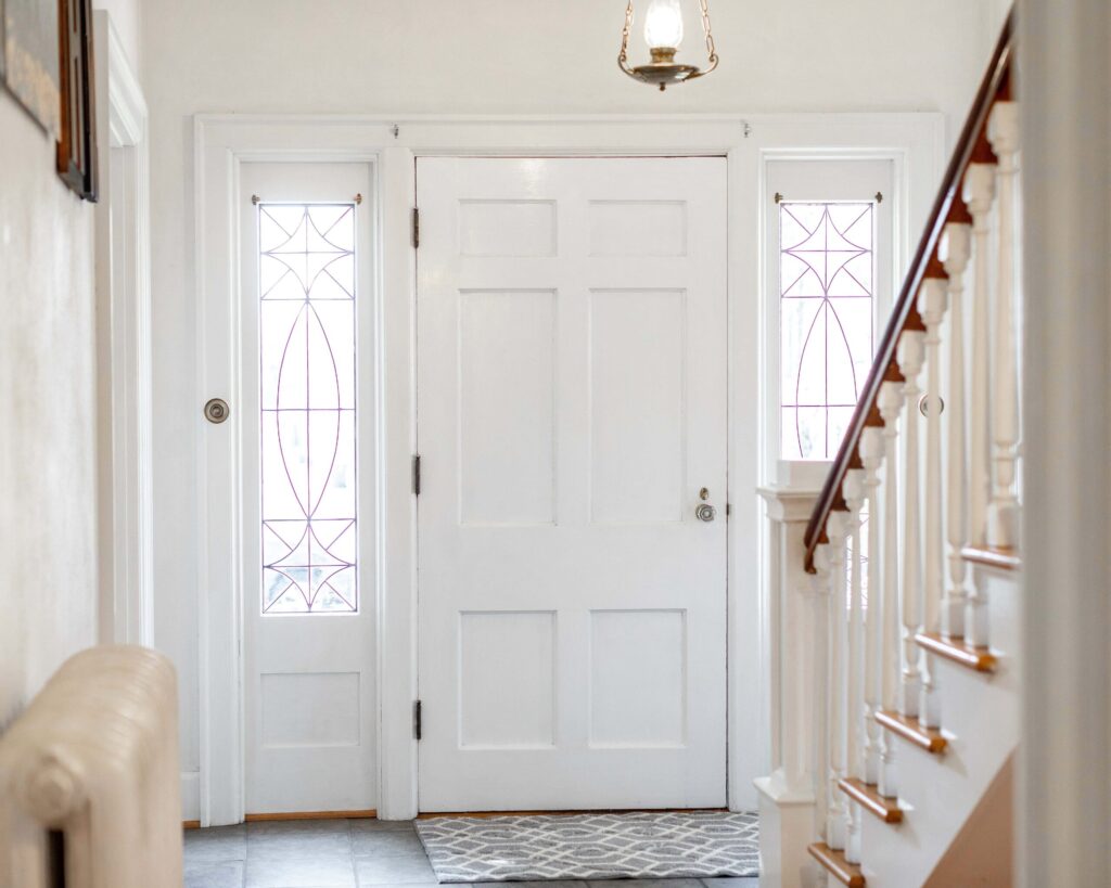 Wallaby energy-efficient white entry door with decorative sidelights, enhancing natural light and classic interior foyer design