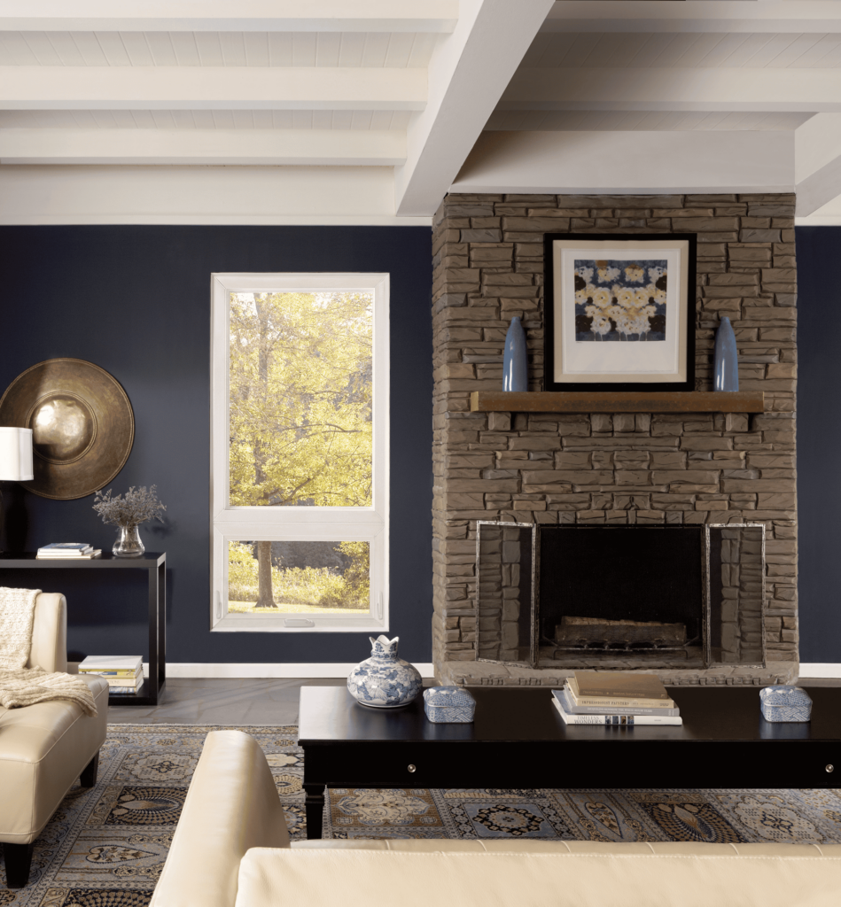 Wallaby Windows double-hung window installation beside stone fireplace in cozy living room