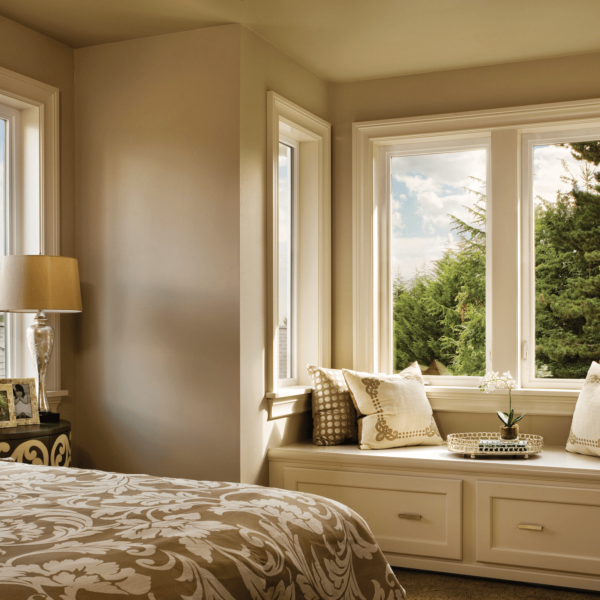 Wallaby Windows double-hung bay window installation in cozy bedroom with built-in seating overlooking residential neighborhood