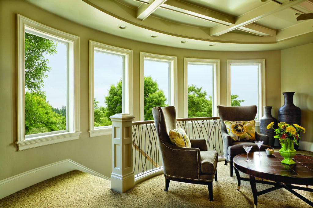 Bright sitting area with multiple tall picture and casement windows providing expansive outdoor views and natural light