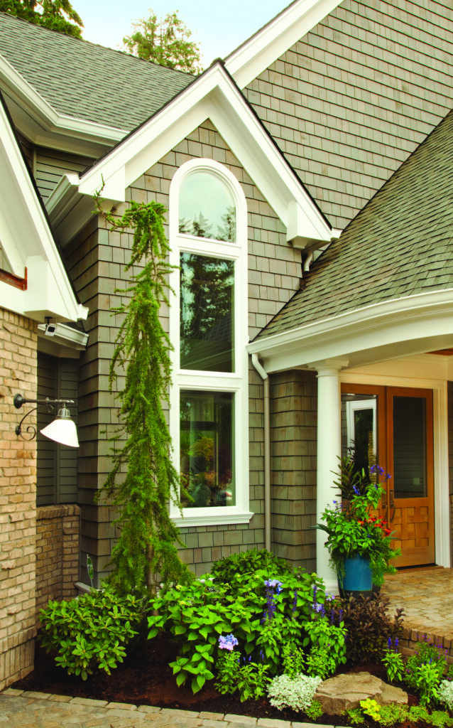 Exterior home with tall arched window and white trim, highlighting custom window installation and craftsmanship by Wallaby Windows