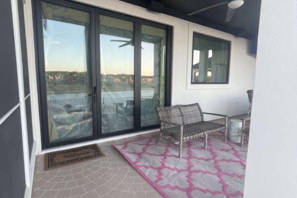 Black framed sliding glass patio doors overlooking waterfront view, professionally installed by Wallaby Windows for outdoor living spaces