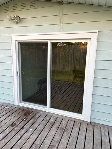 Newly installed sliding glass patio door by Wallaby Windows with clean white framing and enhanced glass clarity, improving backyard access and energy efficiency