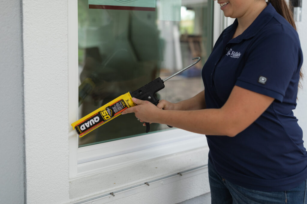 Wallaby technician applying professional-grade sealant to window frame, ensuring airtight installation, durability, and long-term performance
