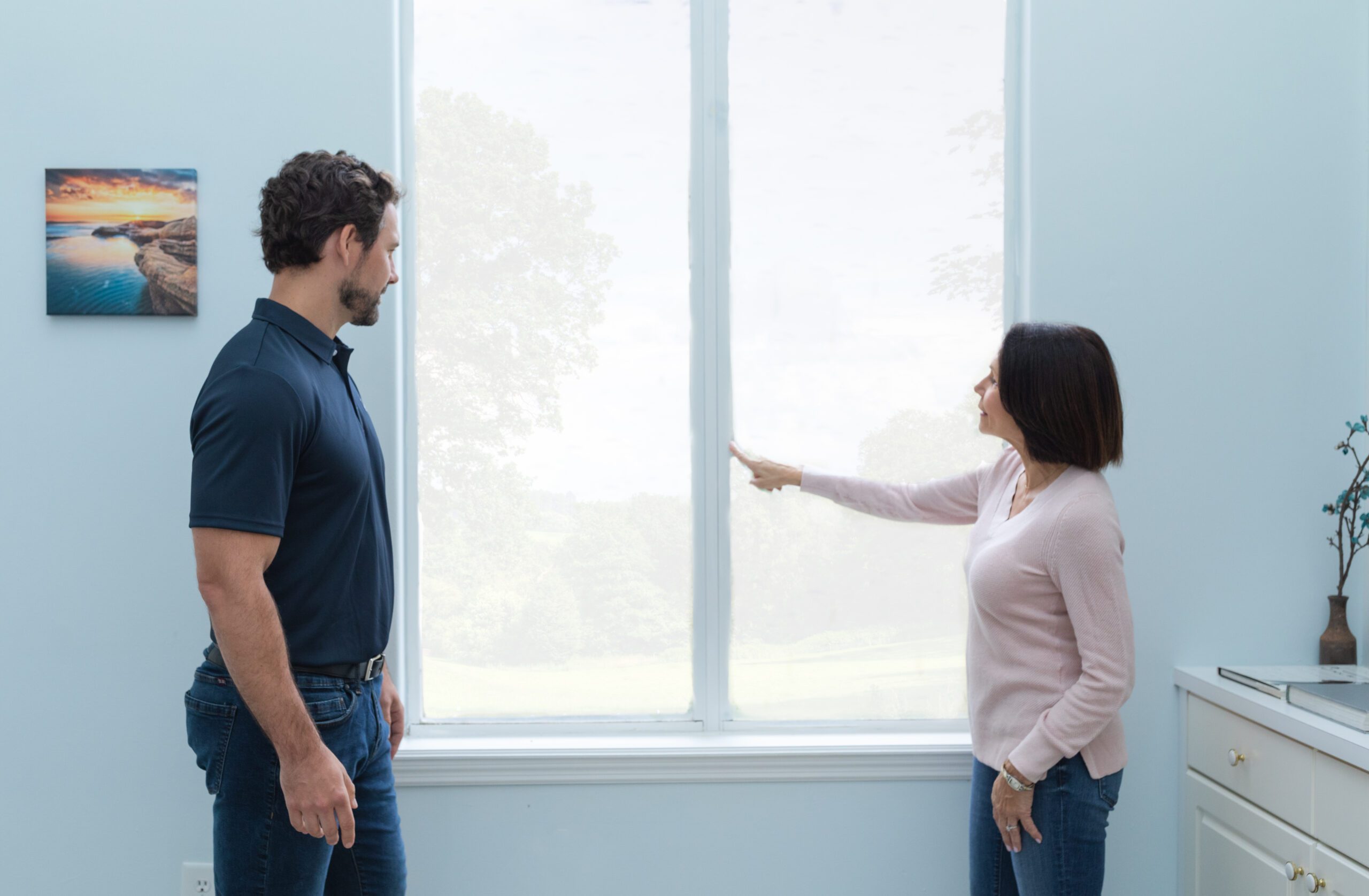 Wallaby Windows representative discussing window replacement options with homeowner, pointing out glass features and energy efficiency benefits