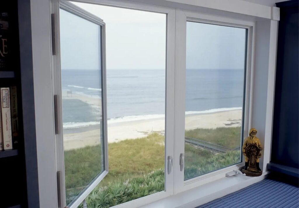 Coastal impact windows installed in a beachfront home providing storm protection, wind resistance, and clear ocean views