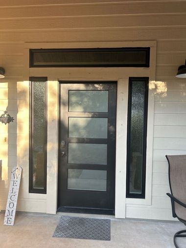 After photo of modern front entry door with frosted glass panels, sidelights, and transom window installed by Wallaby Windows, showcasing improved energy efficiency, security, and updated curb appeal