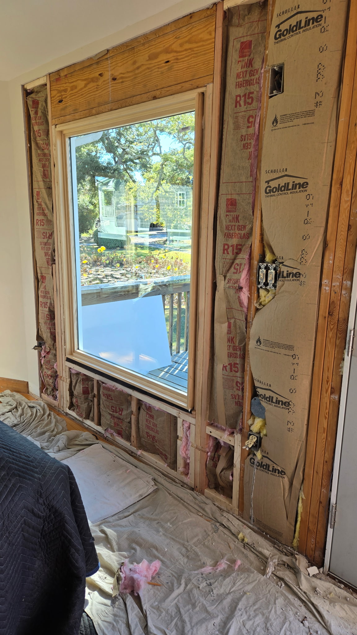 window replacement process showing exposed framing insulation and rough opening preparation for proper sealing in Wilmington coastal Carolina home