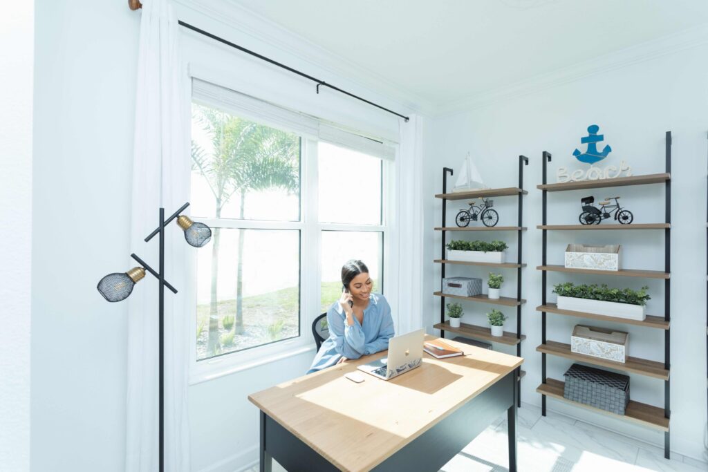 Woman working on laptop beside large bright windows with Wallaby’s guaranteed protection