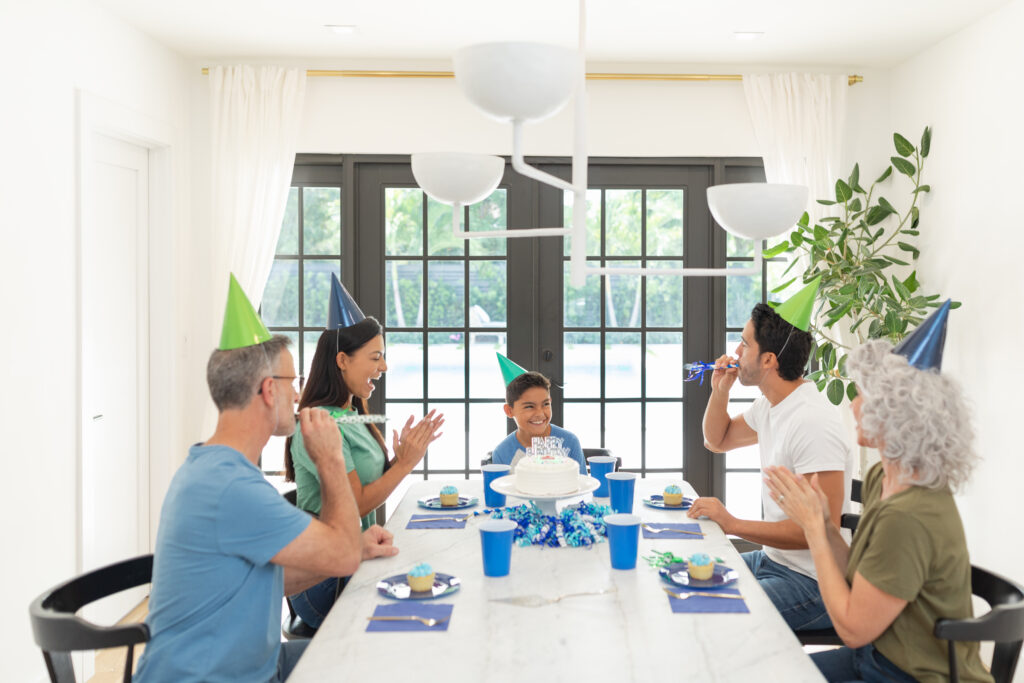 Family celebrating around a table in a Durham NC home with new replacement windows installed by Wallaby Windows