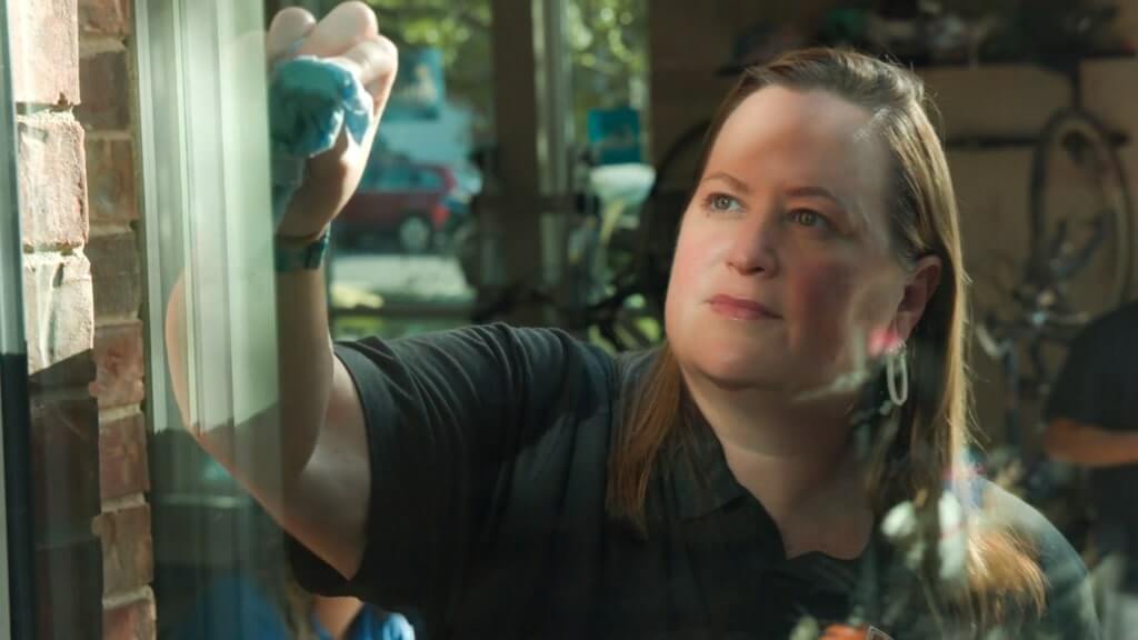 Wallaby team member cleaning window glass after installation
