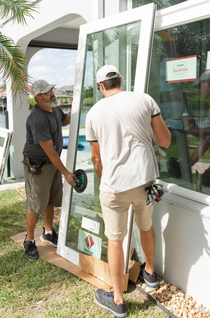 Wallaby installers carefully carrying a replacement glass door